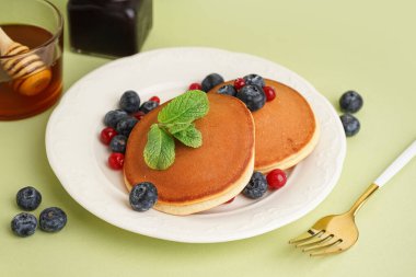 Yeşil arka planda böğürtlenli lezzetli krepler