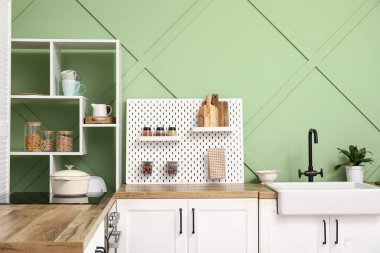 Tahta, lavabo ve ev bitkisi yeşil duvarın yanında.