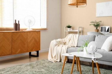 Evdeki sehpanın üzerinde modern elektrikli vantilatör.