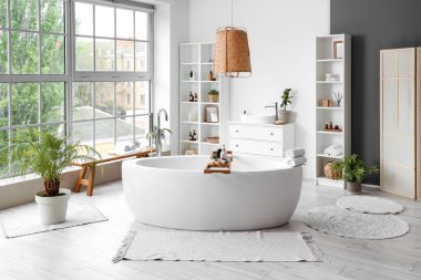 Küveti, raf ünitesi ve lavabosu olan şık bir banyo.