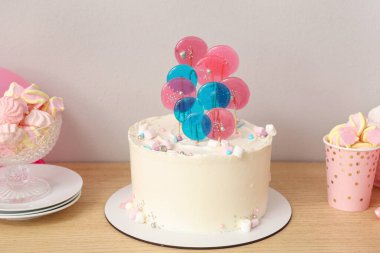 Beyaz duvara karşı masada doğum günü partisi için şekerli pasta.