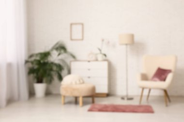 Oturma odasında rahat koltuk, halı ve yastıklı puf. Bulanık görünüm