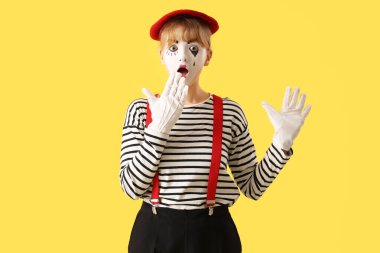 Sarı arka planda şaşırmış kadın pandomimisti.