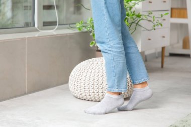 Kot pantolonlu kadın bacakları ve evde ısıtmalı çoraplar.