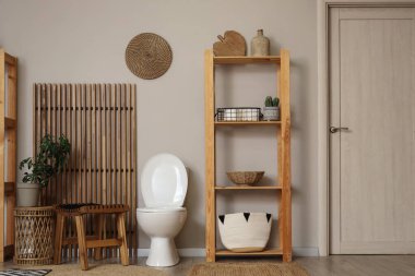 Tuvaletin içinde klozet, masa ve raf ünitesi var.