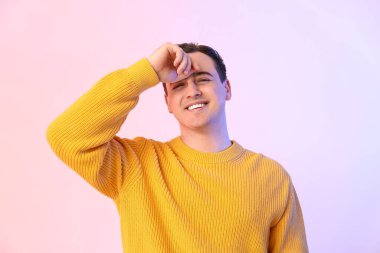 Renkli arka planda yakışıklı, mutlu genç bir adam.