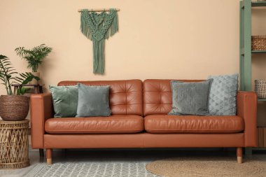 Oturma odasının iç tarafında rahat bir kanepe ve bitkiler var.