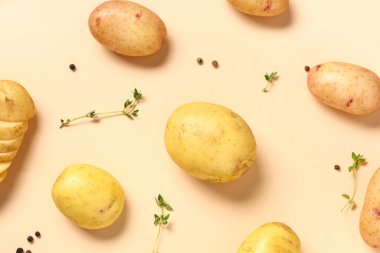 Kekikli çiğ patates ve bej arka planda biber.