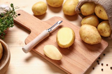 Tahta kesmek çiğ patates, kekik ve ahşap arka planda biber, yakın plan.