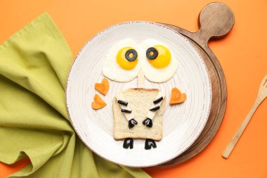 Turuncu arka planda komik çocuk kahvaltısı tabağı.