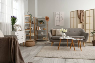 Gri kanepeli, masalı ve katlanır perdeli oturma odasının içinde.