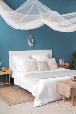 Yatak odasının içinde rüya kapanı ve yatağı var.