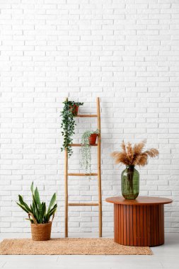 Odanın yanındaki tahta merdiven, masa ve bitkiler.