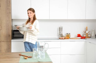 Mutfakta tavuk çorbası hazırlayan genç bir kadın.