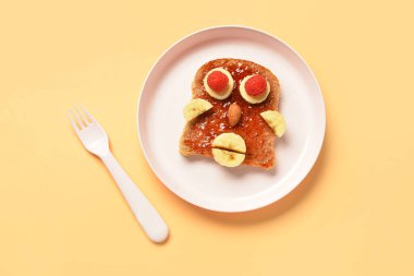 Bej arka planda insan yüzü şeklinde komik çocuk kahvaltısı tabağı.