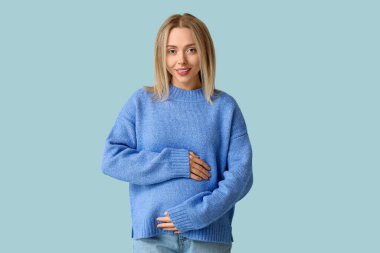 mavi arka plan üzerinde mutlu bir hamile kadın