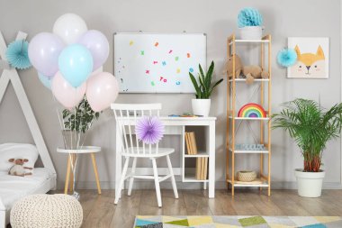 Çocuk odasının içi doğum günü için balonlarla süslenmiş.