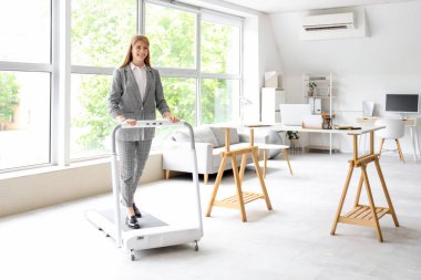 Ofisteki koşu bandında genç iş kadını eğitimi