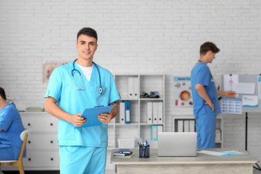 Klinikte panosu olan bir erkek doktor.