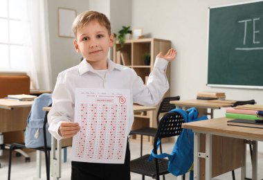 Sınıfta test sonuçları alan tatlı bir okul çocuğu.