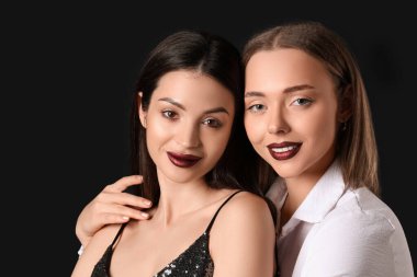 Siyah arka planda sarılan iki farklı genç kadın. Yin Yang konsepti