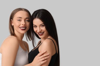 Beyaz arka planda sarılan mutlu iki genç kadın. Yin Yang konsepti