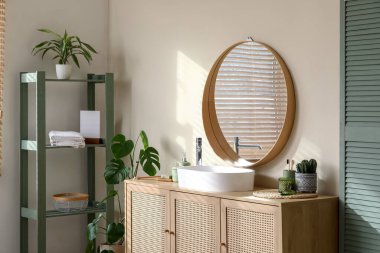 Çekmeceler, raf ünitesi ve banyoda bej duvarın yanındaki katlama ekranı.