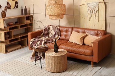 Rahat bir kanepe, raf ünitesi ve şişesi oturma odasının içinde.