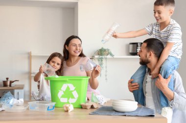 Aile mutfaktaki plastik çöpleri ayırıyor. Küresel Geri Dönüşüm Günü