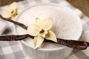 Bir kase vanilya şekeri, kapsüllü ve peçeteli, yakın plan.