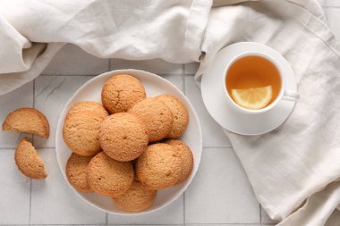 Tatlı kurabiyeli tabak ve beyaz fayanslı sıcak çay.