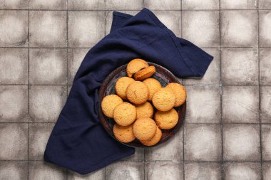 Gri fayans zemininde tatlı kurabiyeler olan tabak