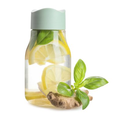 Beyaz arka planda zencefil ve fesleğenli taze limon karıştırılmış spor şişesi.