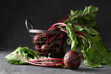 Siyah arka planda taze pancar kökleri olan sepet.