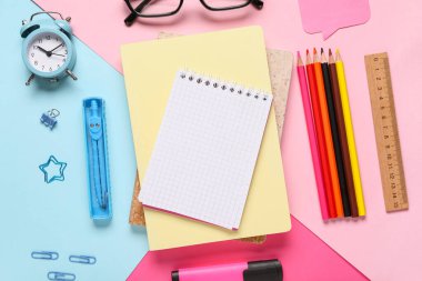 Gözlüklü kompozisyon, çalar saat, not defterleri ve okul malzemeleri renk arkaplanı, yakın plan