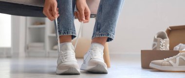 Genç bir kadın dükkanda yeni ayakkabılar deniyor.