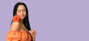 Leylak arka planında Gerbera 'sı olan güzel, Afro-Amerikalı bir kadın. Mesaj için yeri var.