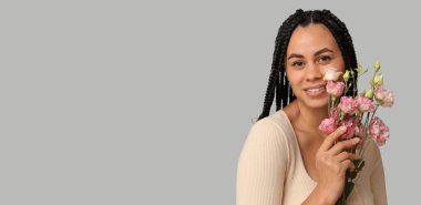 Gri arkaplanlı ve yazı için yeri olan güzel Afro-Amerikalı kadın.