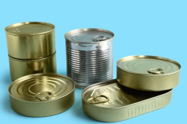 Mavi arka planda balık dolu teneke kutular