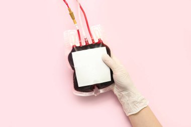 Pembe arka planda kan torbası olan kadın doktor. Dünya Bağış Günü