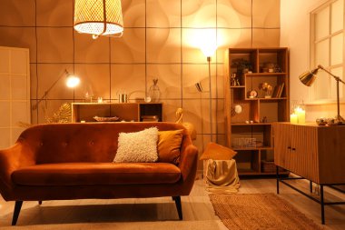 Parlayan lambalar ve gece kanepesi olan şık bir oturma odası.