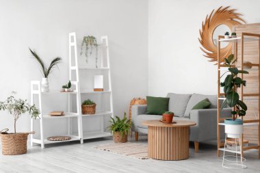 Rafları ve çiçekleri olan şık bir oturma odası.