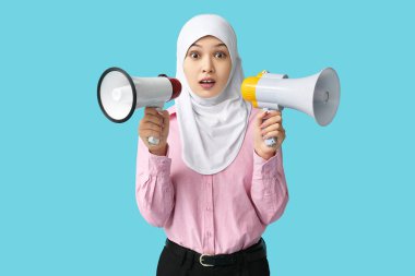 Mavi arka planda megafonlarla genç Asyalı Müslüman kadını şoke etti. Ulusal Duyulma Günü