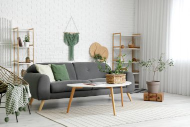 Bambu saplı ve kanepeli modern oturma odasının içi aydınlık.