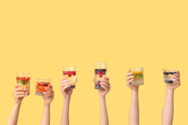 Sarı zemin üzerinde aşılanmış su olan birçok el