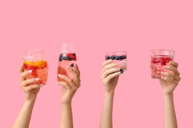 Pembe arka planda erimiş su olan birçok el