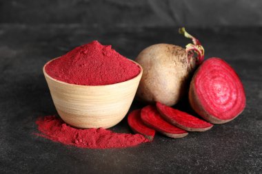 Canlı pancar tozu dolu ahşap kaseler taze pancar ve siyah arka planda dilimler.