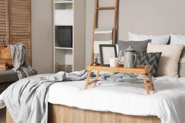 Yatak odasında çaydanlık, fincan ve çerçeve ile tepsi