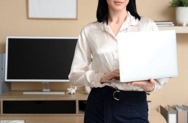 Modern ofiste dizüstü bilgisayarlı genç bir kadın. Yakın çekim.