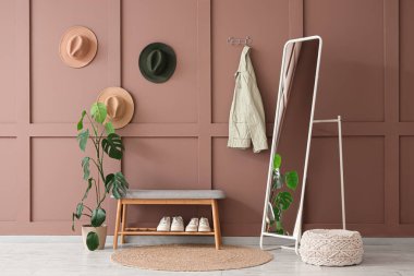 Yumuşak bank, ayna ve şapkalı şık bir koridor.